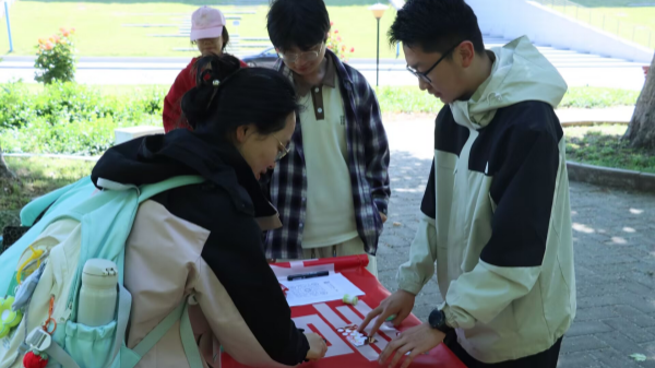 图为在“红色拼图”摊位,学生通过复原历史图片重温五四峥嵘岁月_副本.png